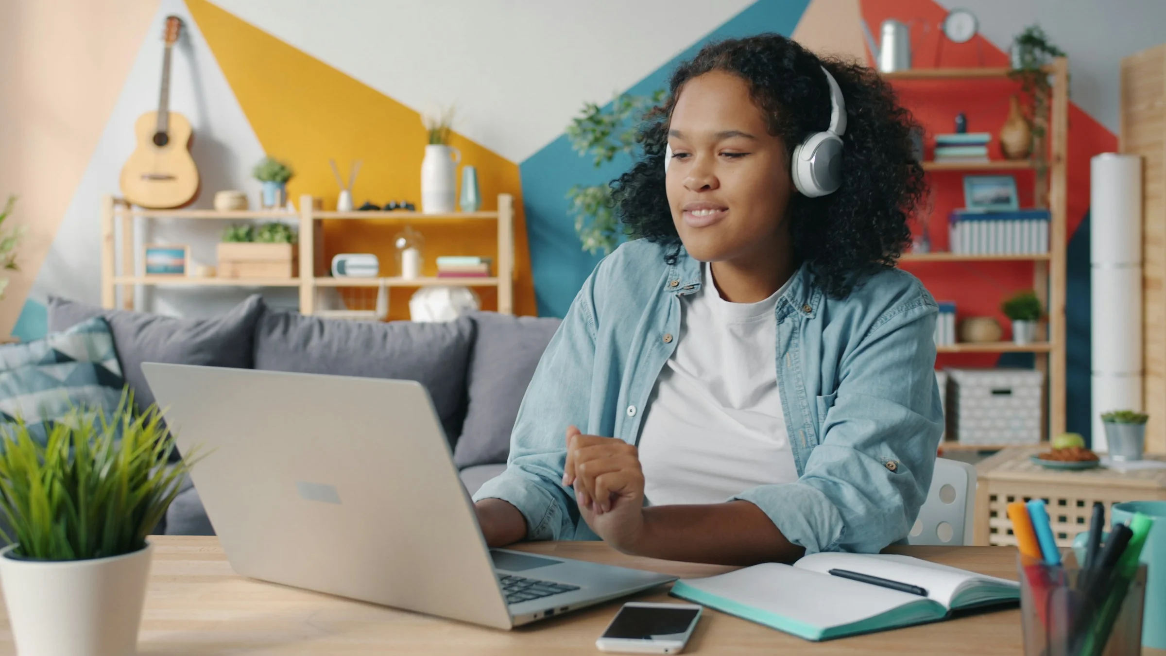 A sixth-form student mid-conversation during an online lesson at her laptop.